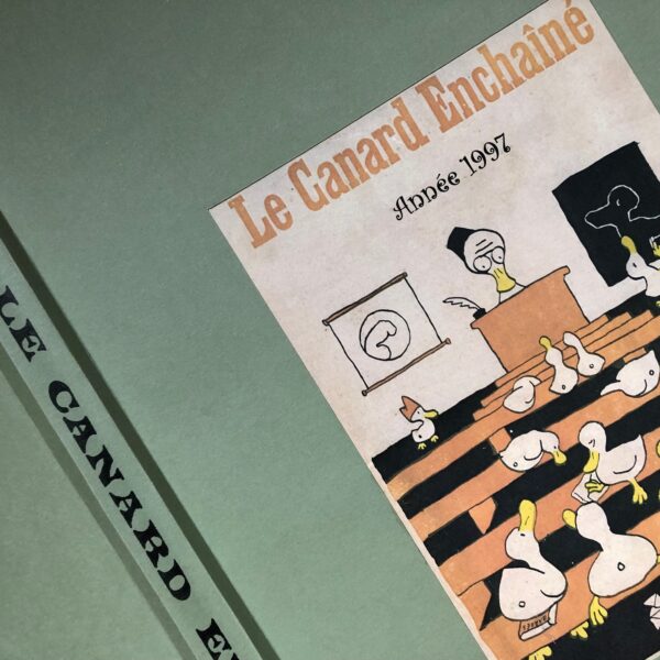 Couac ! | Année 1997 du Canard Enchaîné complète et brochée | Année complète et brochée 1997. Grand in folio 57.5 X 35.5 cm, feuilles parfaitement massicotées à ce format. 52 numéros originaux / 416 pages Les brochures sont réalisées par un artisan-brocheur, dans un très beau papier – Fedrigoni, dans la gamme Materica – 360 g, dont la fibre de coton procure un toucher incomparable, chargé en matière. Les couleurs crayeuses rappellent aussi les éléments : Terra Rossa utilisée pour les années paires, Verdigris, pour les années impaires. Ce papier est teinté dans la masse et fabriqué avec 40% de fibres CTMP, 25% de fibres vierges, 25% de fibres recyclées et 10% de fibres de coton. - Sans acide ECF – Ph neutre – certifié FSC - Au centre de la couverture est enchâssée la reproduction fidèle du dessin de Lucien Laforge - un des tous premiers dessinateurs au Canard Enchainé - qui illustrait la pochette offerte aux abonnés de la première heure, soit ceux de 1916... la quatrième de couverture reprend le cabochon de cette même pochette d'origine, figurant un poilu lisant le "Canard". Le dos est carré et collé, les plats sont souples avec rabats intérieurs. Tous les numéros sont solidaires et ordonnés suivant l'ordre chronologique, ils peuvent comporter quelques jaunissements au droit des anciennes pliures ou petites restaurations. La photo présentée correspond à celle de l'exemplaire original en vente, prise en lumière naturelle (ce n'est pas une photo générique).     | IMG 8301