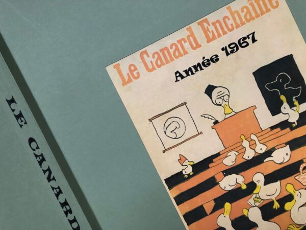 Couac ! | Année 1967 du Canard Enchaîné complète et brochée | Année complète et brochée 1967. Grand in folio 57.5 X 37.5 cm, feuilles parfaitement massicotées à ce format. 52 numéros originaux / 416 pages Les brochures sont réalisées par un artisan-brocheur, dans un très beau papier – Fedrigoni, dans la gamme Materica – 360 g, dont la fibre de coton procure un toucher incomparable, chargé en matière. Les couleurs crayeuses rappellent aussi les éléments : Terra Rossa utilisée pour les années paires, Verdigris, pour les années impaires. Ce papier est teinté dans la masse et fabriqué avec 40% de fibres CTMP, 25% de fibres vierges, 25% de fibres recyclées et 10% de fibres de coton. - Sans acide ECF – Ph neutre – certifié FSC - Au centre de la couverture est enchâssée la reproduction fidèle du dessin de Lucien Laforge - un des tous premiers dessinateurs au Canard Enchainé - qui illustrait la pochette offerte aux abonnés de la première heure, soit ceux de 1916... la quatrième de couverture reprend le cabochon de cette même pochette d'origine, figurant un poilu lisant le "Canard". Le dos est carré et collé, les plats sont souples avec rabats intérieurs. Tous les numéros sont solidaires et ordonnés suivant l'ordre chronologique, ils peuvent comporter quelques jaunissements au droit des anciennes pliures ou petites restaurations. La photo présentée correspond à celle de l'exemplaire original en vente, prise en lumière naturelle (ce n'est pas une photo générique). | IMG 8333